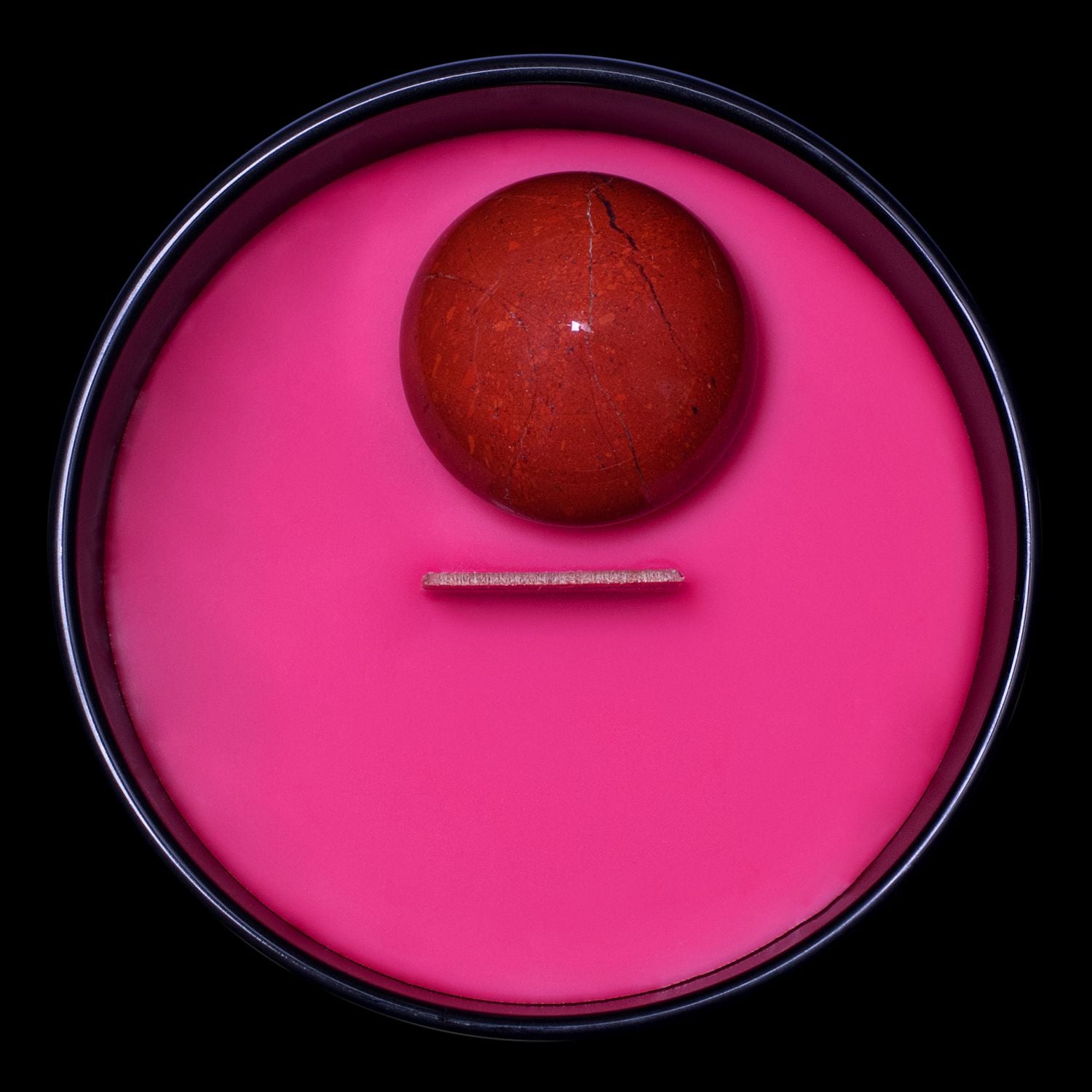 Birds Eye View Of The Naturally Wicked Hypnotwist Confront Candle Featuring Plant-based Soy Red Wax Scented With Ringmaster's Rum & Includes A Red Jasper Crystal Spinning Top & Wooden Wick